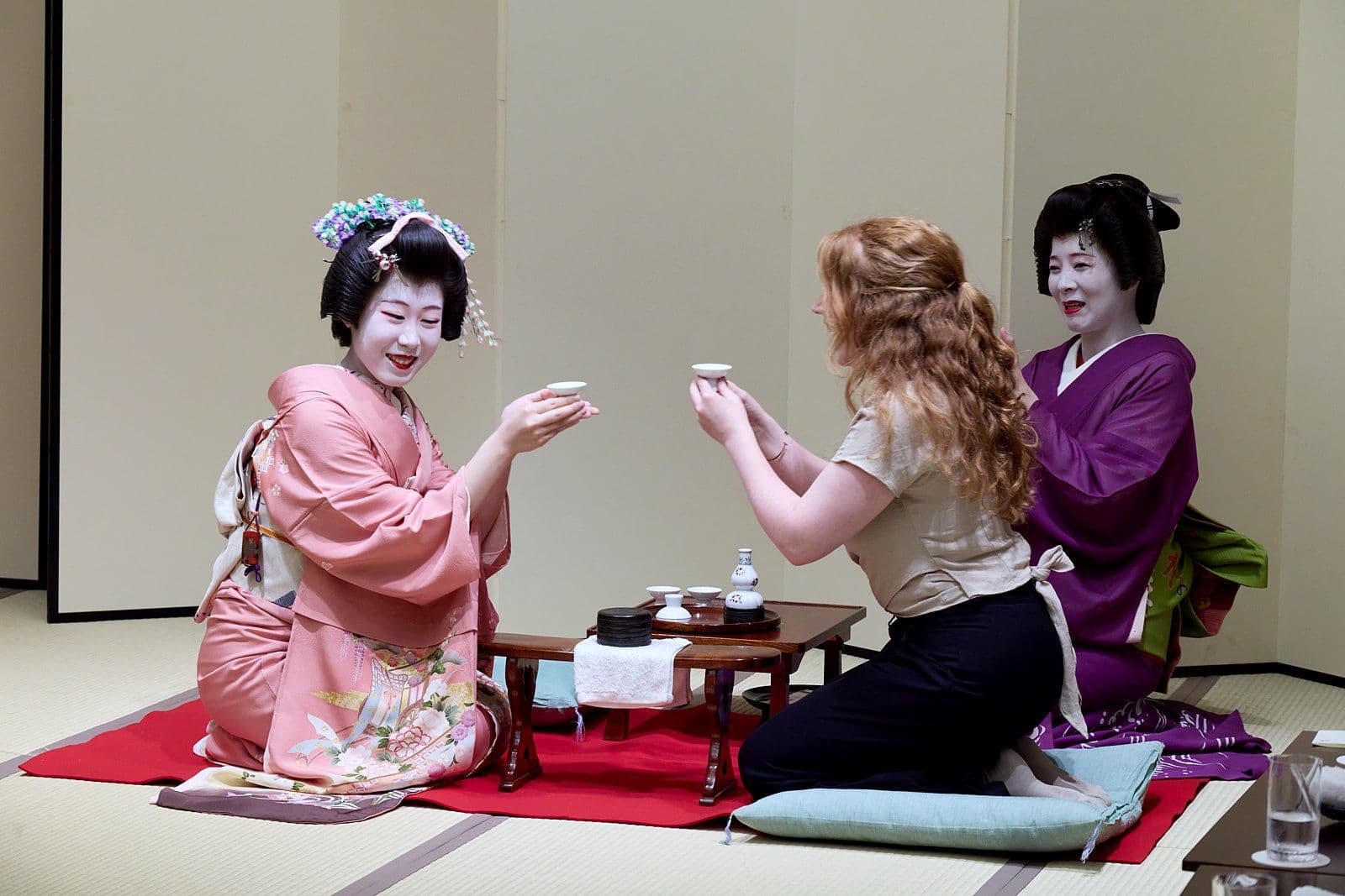 一位藝妓與一位賓客互相舉杯。