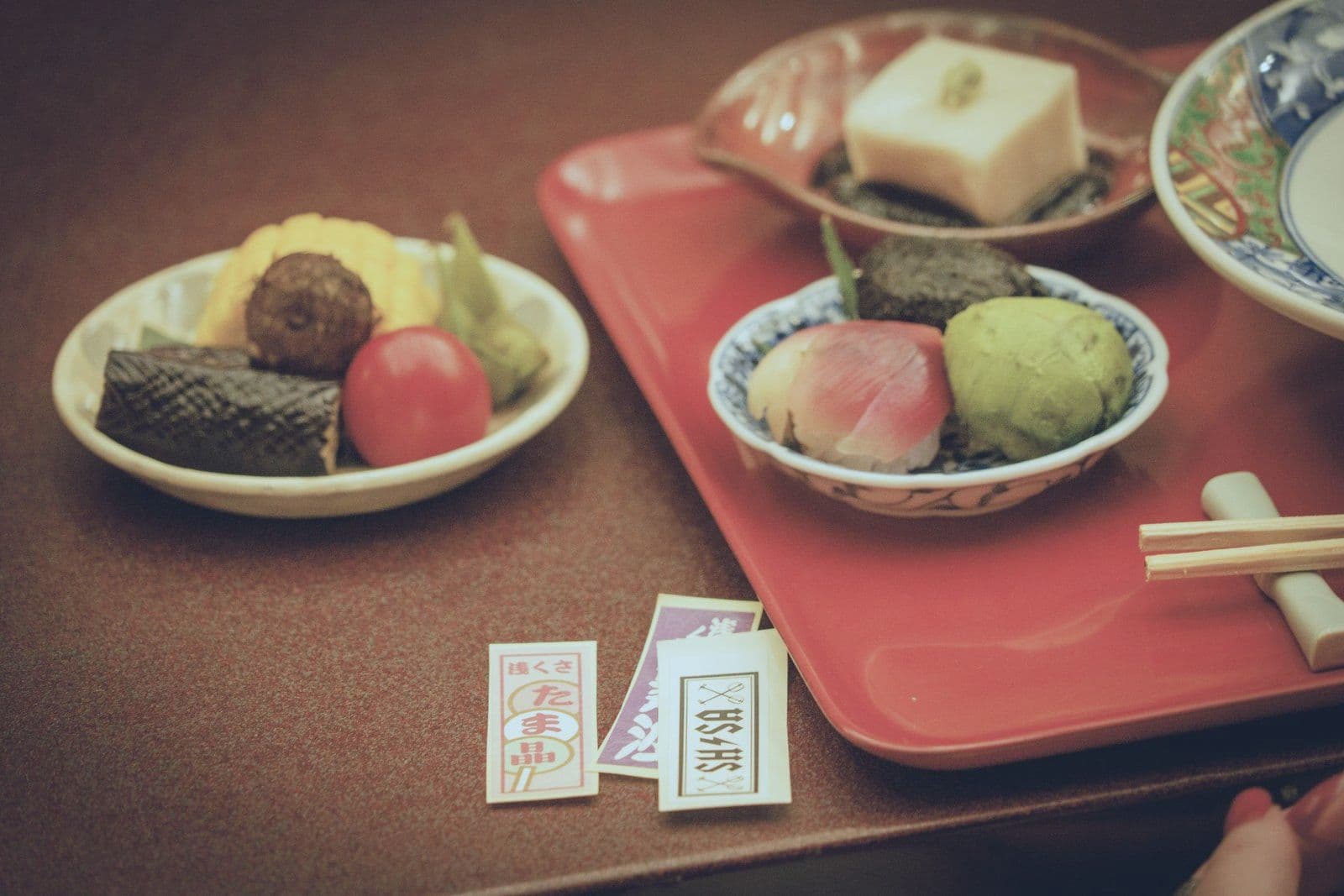 紅色托盤上擺著幾小碗當季日本料理與和菓子。